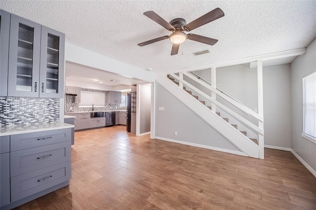 252 W Brookins Ave, Eagle Lake, FL 33839 - unfurnished living room with ceiling fan, a textured ceiling, light wood-style flooring, and stairs