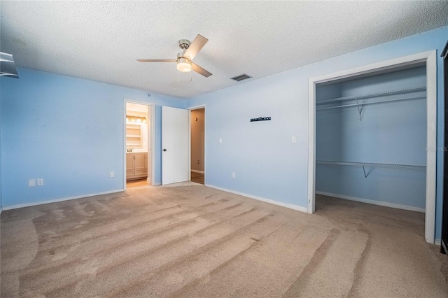 252 W Brookins Ave, Eagle Lake, FL 33839 - unfurnished bedroom featuring carpet, a closet, a textured ceiling, a ceiling fan, and ensuite bath