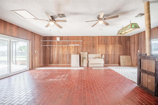 252 W Brookins Ave, Eagle Lake, FL 33839 - unfurnished living room featuring wooden walls, a ceiling fan, and brick patterned floors