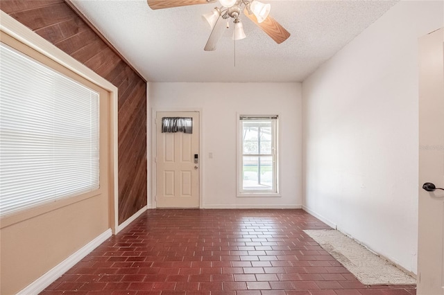 252 W Brookins Ave, Eagle Lake, FL 33839 - entrance foyer featuring wooden walls, a textured ceiling, ceiling fan, and brick patterned flooring
