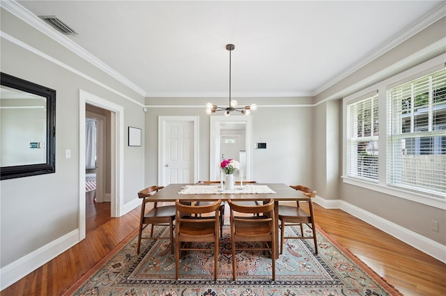 1515 King Ave, Lakeland, FL 33803 - dining room featuring light wood-type flooring, a chandelier, and ornamental molding