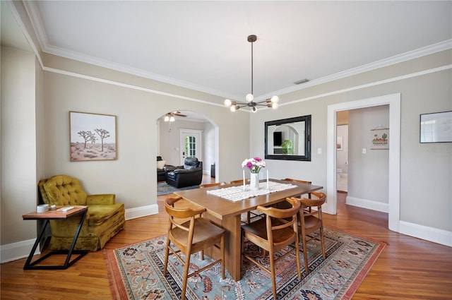 1515 King Ave, Lakeland, FL 33803 - dining room with arched walkways, ornamental molding, a chandelier, and light wood-type flooring