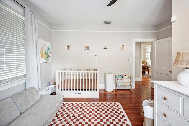 1515 King Ave, Lakeland, FL 33803 - bedroom with dark wood-type flooring, a crib, and a ceiling fan