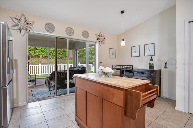 11607 Hammocks Glade Dr, Riverview, FL 33569 - kitchen with stainless steel fridge with ice dispenser, wooden counters, light tile patterned floors, decorative light fixtures, and lofted ceiling