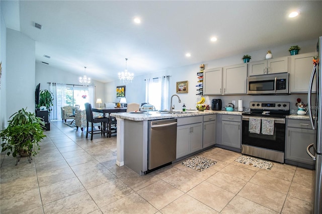 8031 Brookeshire Dr, Lakeland, FL 33809 - kitchen featuring appliances with stainless steel finishes, gray cabinets, a chandelier, a peninsula, and recessed lighting