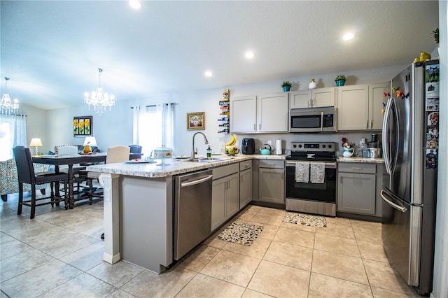 8031 Brookeshire Dr, Lakeland, FL 33809 - kitchen with stainless steel appliances, gray cabinets, a peninsula, a chandelier, and recessed lighting