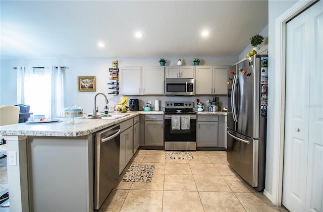 8031 Brookeshire Dr, Lakeland, FL 33809 - kitchen featuring appliances with stainless steel finishes, gray cabinets, a peninsula, recessed lighting, and light tile patterned flooring