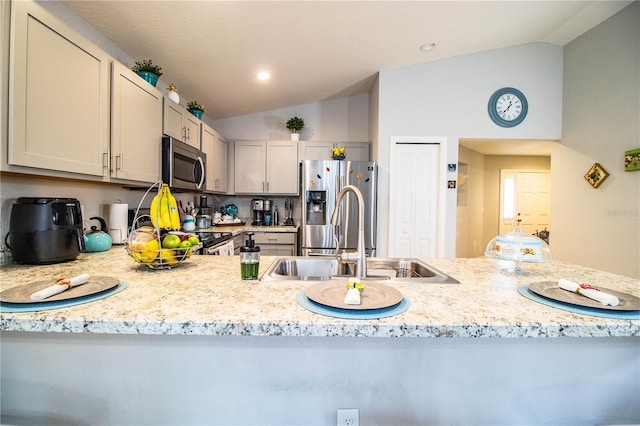 8031 Brookeshire Dr, Lakeland, FL 33809 - kitchen with vaulted ceiling, appliances with stainless steel finishes, recessed lighting, and light stone counters