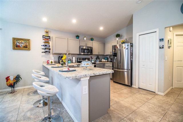 8031 Brookeshire Dr, Lakeland, FL 33809 - kitchen with stainless steel appliances, a peninsula, a breakfast bar, gray cabinets, and lofted ceiling