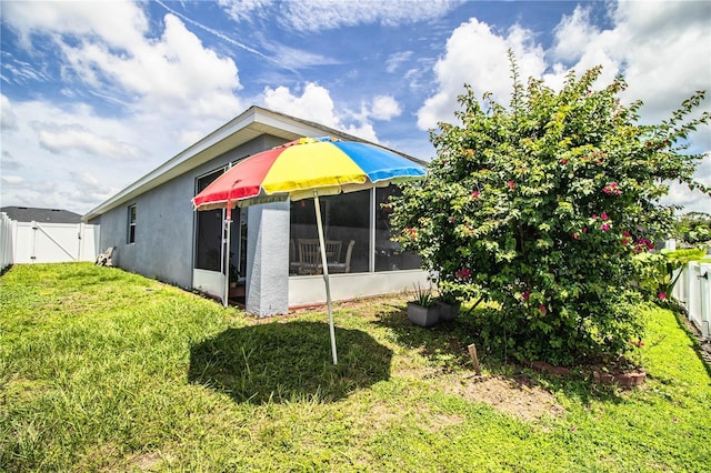 8031 Brookeshire Dr, Lakeland, FL 33809 - back of property featuring a gate, a fenced backyard, stucco siding, and a sunroom