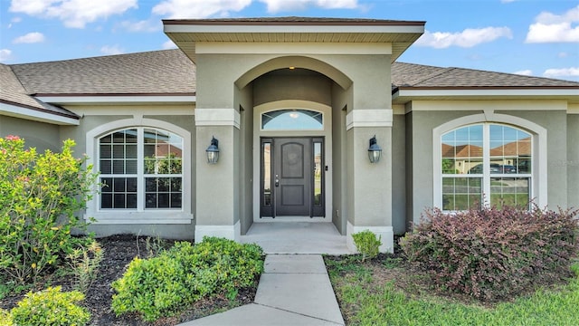 1156 Normandy Heights Cir, Winter Haven, FL 33880 - view of exterior entry with a shingled roof and stucco siding