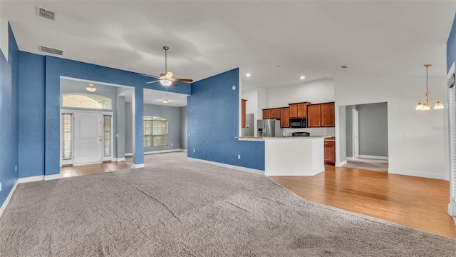 1156 Normandy Heights Cir, Winter Haven, FL 33880 - unfurnished living room with light colored carpet, a chandelier, a ceiling fan, and recessed lighting