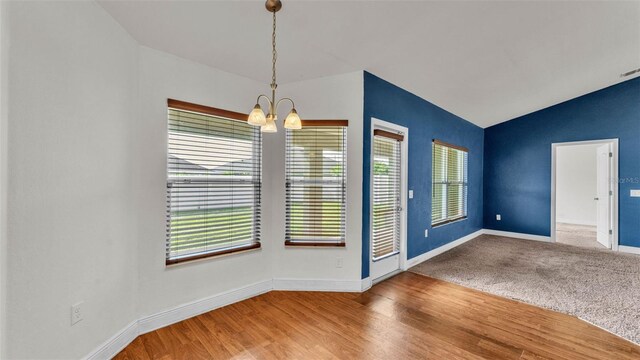 1156 Normandy Heights Cir, Winter Haven, FL 33880 - unfurnished dining area featuring a chandelier, vaulted ceiling, and wood finished floors