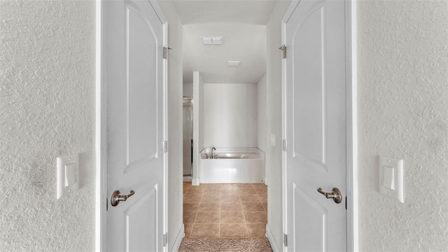1156 Normandy Heights Cir, Winter Haven, FL 33880 - corridor featuring a textured wall and tile patterned flooring