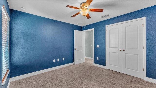 1156 Normandy Heights Cir, Winter Haven, FL 33880 - unfurnished bedroom featuring carpet flooring, a closet, a ceiling fan, and a textured wall