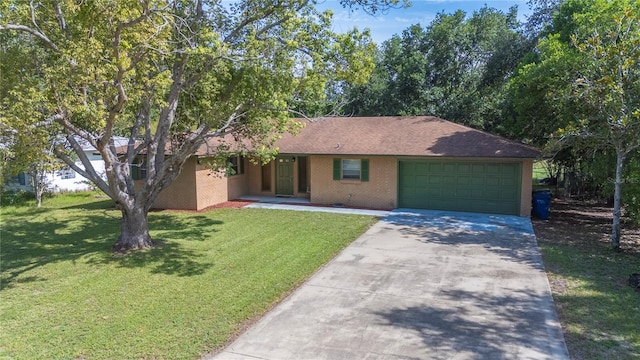 335 W Cummings St, Lake Alfred, FL 33850 - ranch-style home featuring an attached garage, brick siding, concrete driveway, and a front yard