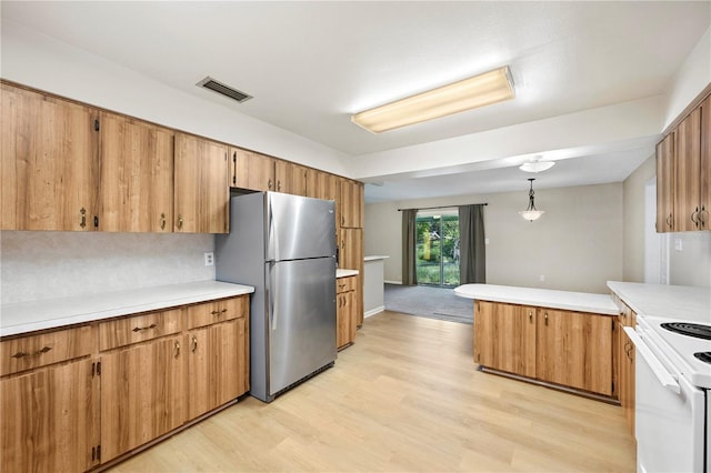 335 W Cummings St, Lake Alfred, FL 33850 - kitchen featuring freestanding refrigerator, white range with electric stovetop, light countertops, a peninsula, and light wood-type flooring