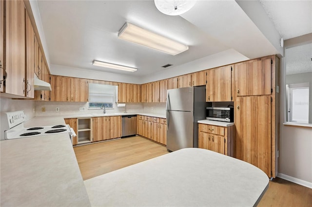335 W Cummings St, Lake Alfred, FL 33850 - kitchen featuring appliances with stainless steel finishes, light wood finished floors, light countertops, and under cabinet range hood