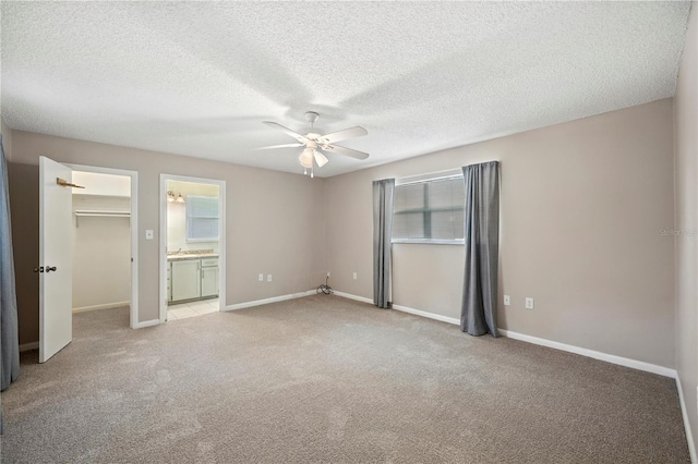 335 W Cummings St, Lake Alfred, FL 33850 - unfurnished bedroom featuring light carpet, a spacious closet, ceiling fan, a textured ceiling, and ensuite bathroom
