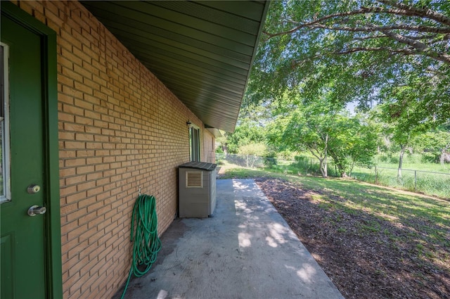 335 W Cummings St, Lake Alfred, FL 33850 - view of side of property featuring brick siding, a fenced backyard, and a patio