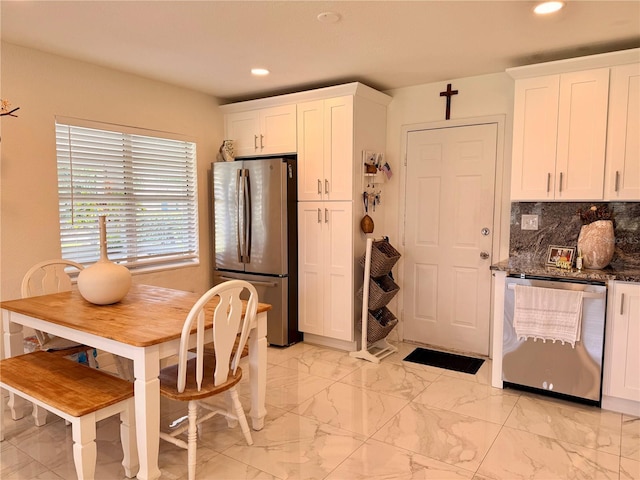 1302 W 8th St, Lakeland, FL 33805 - kitchen with appliances with stainless steel finishes, recessed lighting, white cabinets, light marble finish flooring, and backsplash