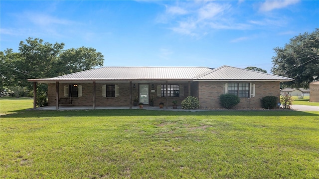 6504 Hereford Dr, Lakeland, FL 33810 - view of front of house featuring a front yard, brick siding, and a metal roof