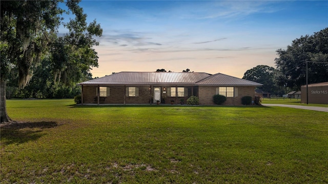 6504 Hereford Dr, Lakeland, FL 33810 - single story home featuring a front yard, a metal roof, and brick siding