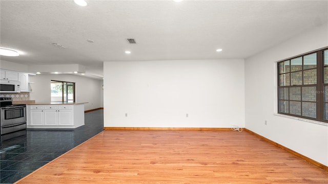 6504 Hereford Dr, Lakeland, FL 33810 - unfurnished living room with wood finished floors and recessed lighting