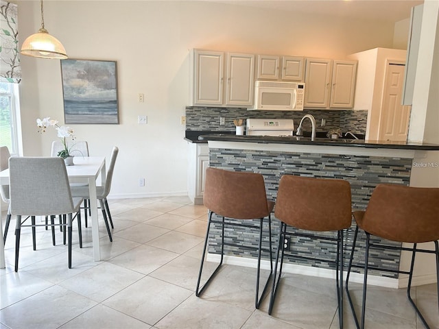3999 Whistlewood Cir, Lakeland, FL 33811 - kitchen featuring white microwave, dark countertops, decorative backsplash, and stove