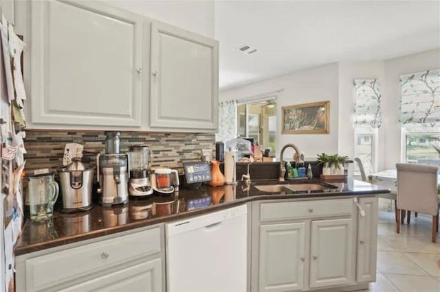 3999 Whistlewood Cir, Lakeland, FL 33811 - bar featuring white dishwasher, backsplash, and light tile patterned floors
