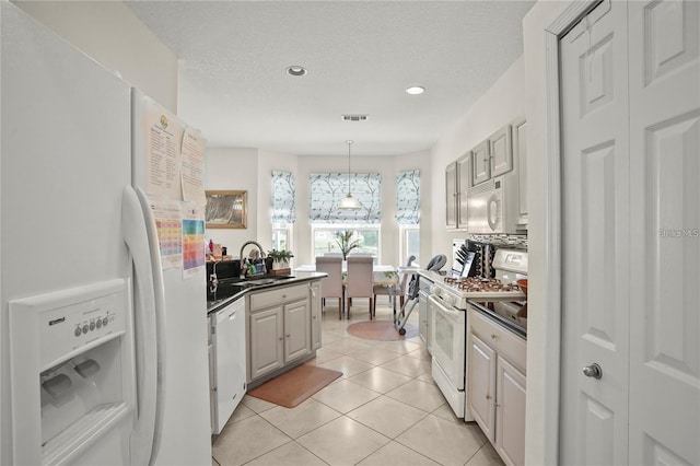 3999 Whistlewood Cir, Lakeland, FL 33811 - kitchen featuring white appliances, dark countertops, light tile patterned floors, recessed lighting, and pendant lighting