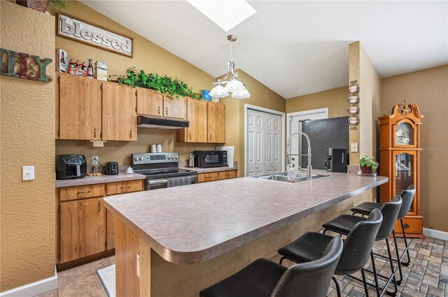 735 Virginia Ave, Auburndale, FL 33823 - kitchen with stainless steel range with electric cooktop, under cabinet range hood, a skylight, black microwave, and a breakfast bar area