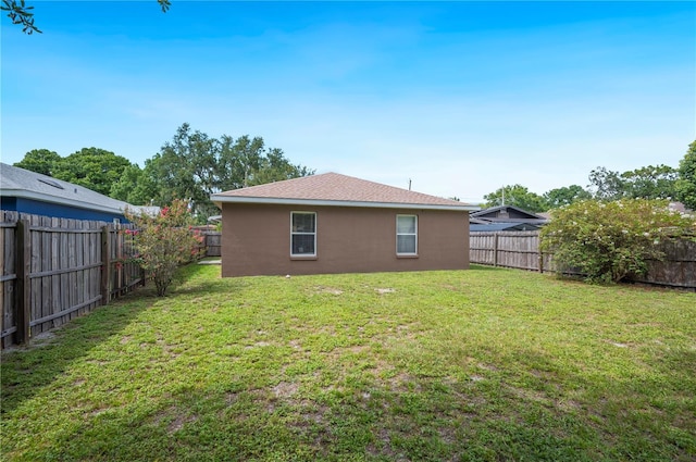 735 Virginia Ave, Auburndale, FL 33823 - rear view of house featuring a fenced backyard and stucco siding