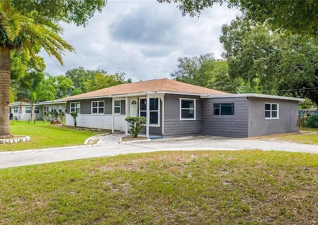1341 Sandy Ln, Clearwater, FL 33755 - ranch-style house with a front lawn