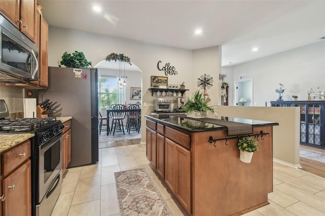 1933 Griffin Trl, Bartow, FL 33830 - kitchen with stainless steel appliances, a kitchen island, recessed lighting, light tile patterned floors, and arched walkways
