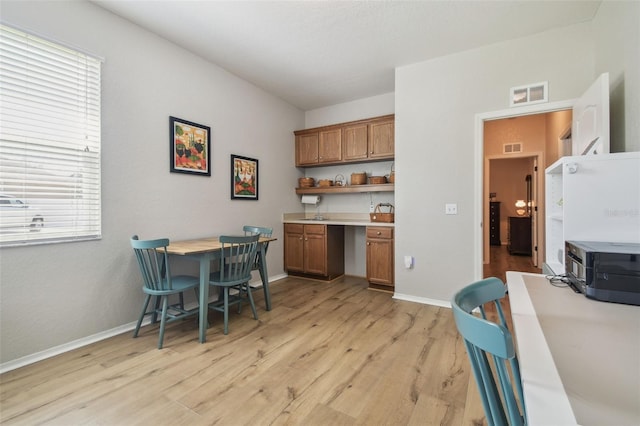1933 Griffin Trl, Bartow, FL 33830 - kitchen featuring brown cabinets, light wood-type flooring, open shelves, and light countertops