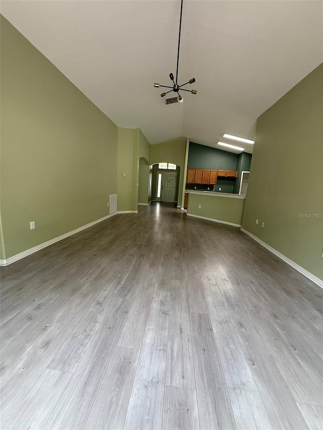 7198 Cedarcrest Blvd, Lakeland, FL 33810 - unfurnished living room with a chandelier, vaulted ceiling, dark wood-style flooring, and arched walkways