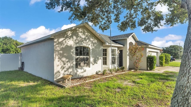 3917 NW Warbler Dr, Winter Haven, FL 33880 - view of side of home with an attached garage, stucco siding, and driveway