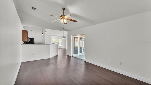3917 NW Warbler Dr, Winter Haven, FL 33880 - unfurnished living room with ceiling fan, dark wood-type flooring, and vaulted ceiling