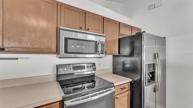 3917 NW Warbler Dr, Winter Haven, FL 33880 - kitchen with stainless steel appliances, light countertops, and brown cabinets