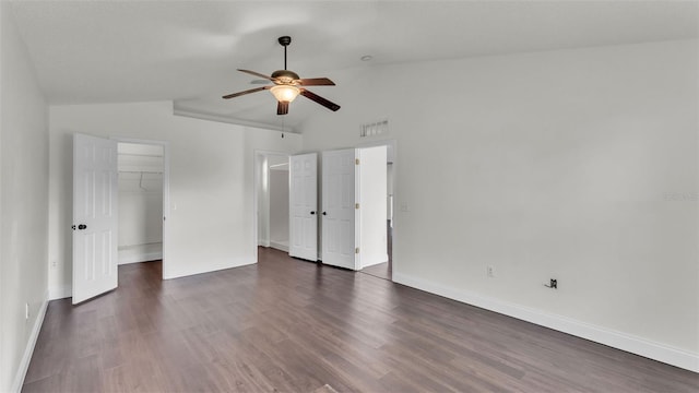 3917 NW Warbler Dr, Winter Haven, FL 33880 - unfurnished bedroom featuring lofted ceiling, dark wood-style floors, ceiling fan, and a walk in closet