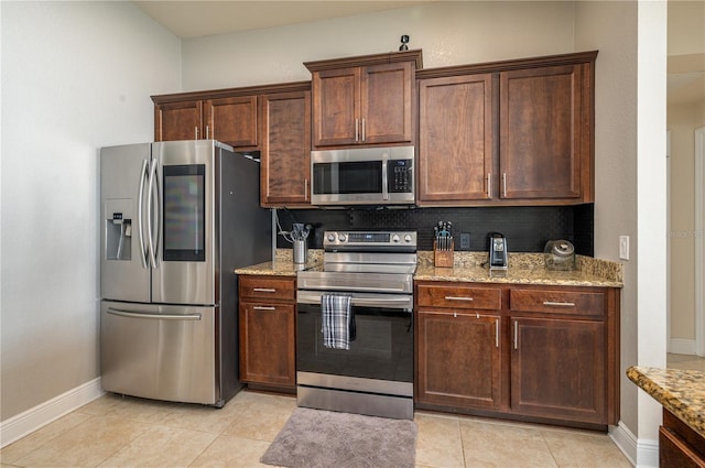 702 Country Walk Cv, Eagle Lake, FL 33839 - kitchen with stainless steel appliances, light stone countertops, decorative backsplash, light tile patterned floors, and dark brown cabinets
