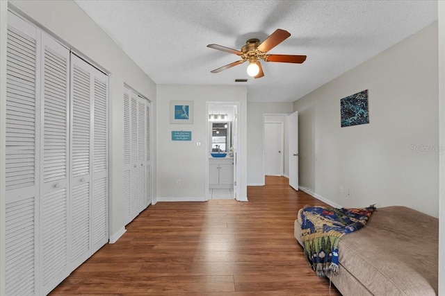 512 Hilldale Rd, Brandon, FL 33510 - unfurnished bedroom with wood finished floors, multiple closets, a textured ceiling, ensuite bathroom, and a ceiling fan