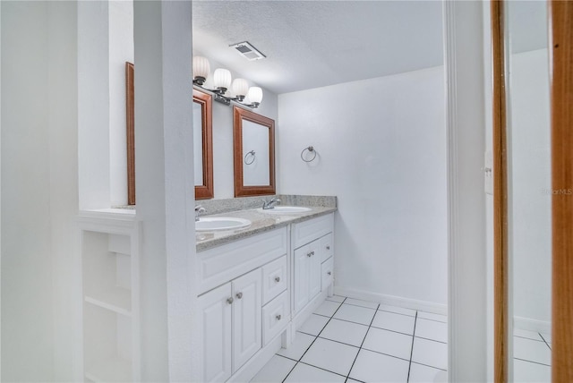 1836 N Crystal Lake Dr Unit 11, Lakeland, FL 33801 - bathroom with double vanity, tile patterned flooring, and a textured ceiling