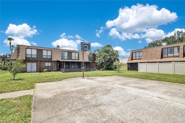 1836 N Crystal Lake Dr Unit 11, Lakeland, FL 33801 - rear view of property with brick siding, a yard, a sunroom, and a shingled roof
