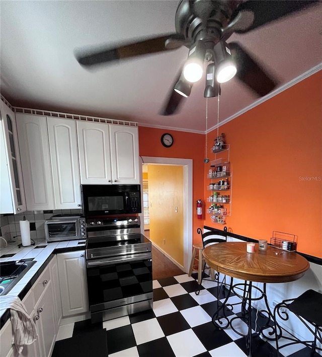 1319 Florida Ave, Saint Cloud, FL 34769 - kitchen featuring tile counters, dark floors, white cabinetry, stainless steel electric stove, and ornamental molding