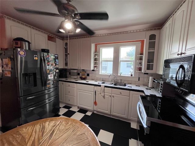 1319 Florida Ave, Saint Cloud, FL 34769 - kitchen with black appliances, light floors, glass insert cabinets, ceiling fan, and tasteful backsplash