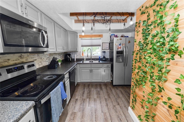 404 Country Ln NE Unit 404, Winter Haven, FL 33881 - kitchen with appliances with stainless steel finishes, wood finished floors, tasteful backsplash, dark countertops, and a textured ceiling