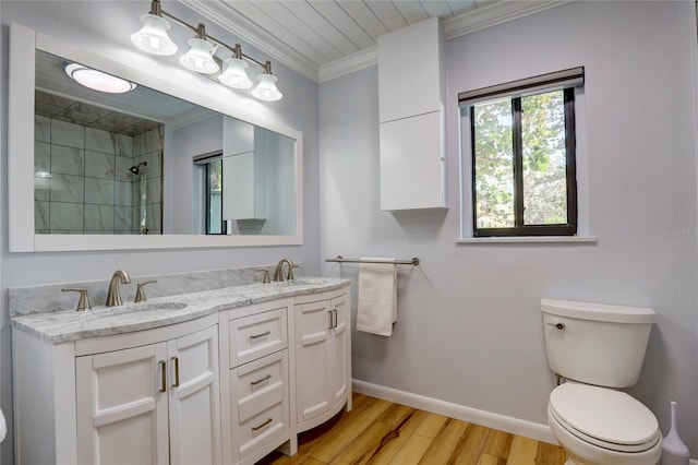 bathroom featuring double sink vanity, toilet, hardwood / wood-style floors, and ornamental molding