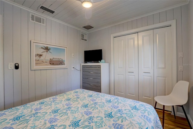 bedroom featuring crown molding, hardwood / wood-style floors, a closet, and ceiling fan